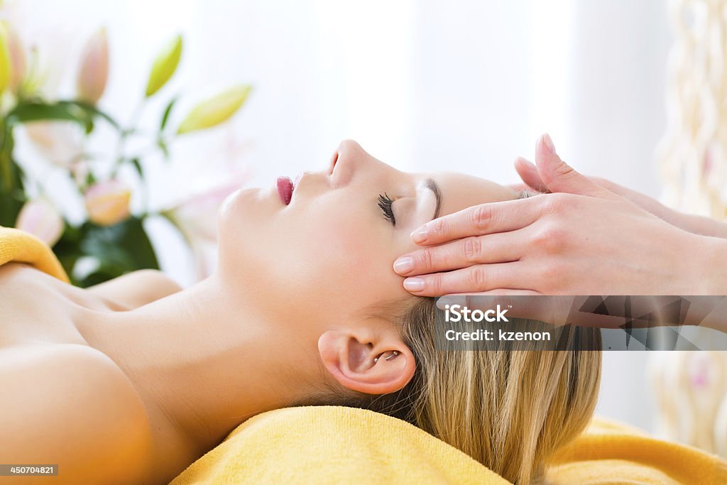 A women receiving a head massage in a spa Wellness - woman receiving head or face massage in spa Reiki Stock Photo