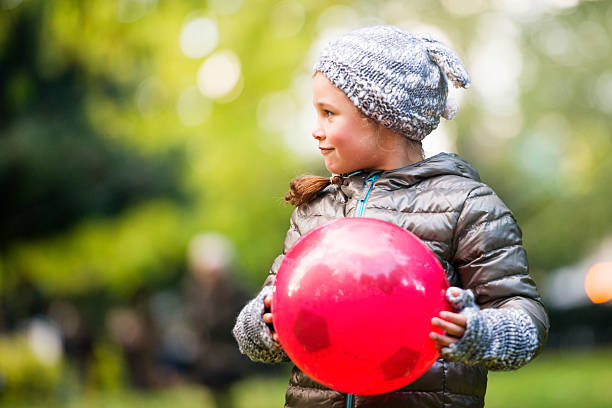 istock Young girl in a park with ball 450705113