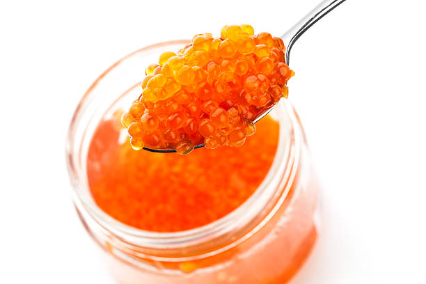 istock Red caviar in metal spoon and jar isolated on white 450708331