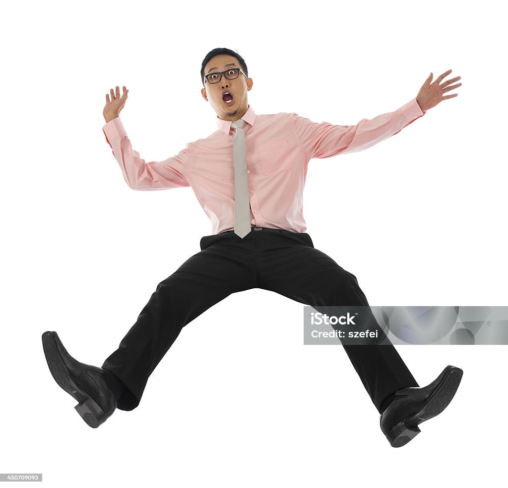 Asian businessman falling backwards Full body shocked young Asian businessman falling backwards open arms, isolated on white background Falling Stock Photo