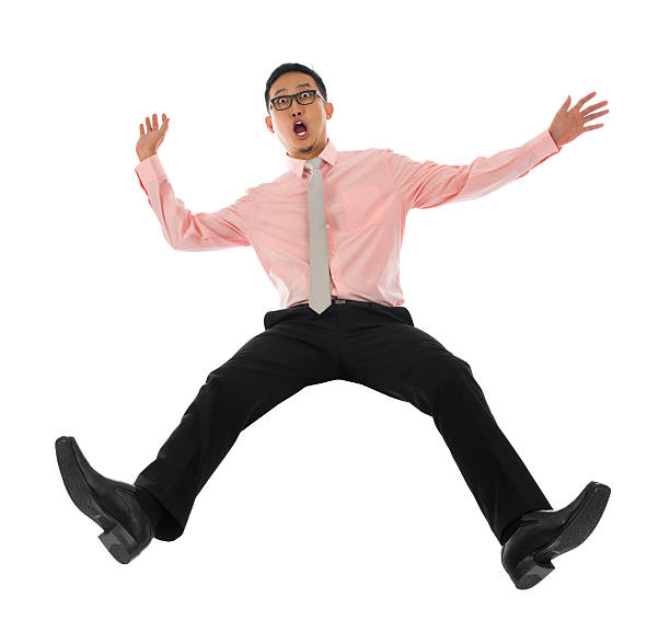 Asian businessman falling backwards Full body shocked young Asian businessman falling backwards open arms, isolated on white background bending over backwards stock pictures, royalty-free photos & images