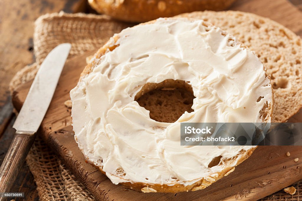 Half of an organic whole grain bagel with cream cheese Healthy Organic Whole Grain Bagel with Cream Cheese Cream Cheese Stock Photo