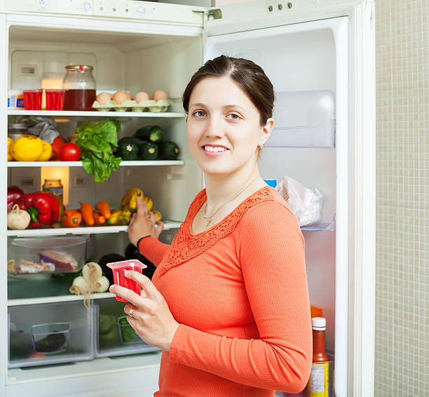 istock Young woman near fridge 450734473
