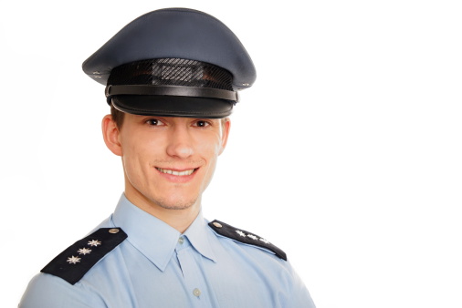 Portrait of young smiling policeman on white background.