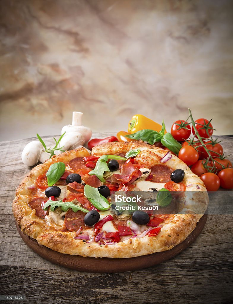 Delicious italian pizza Delicious italian pizza served on wooden table Arugula Stock Photo