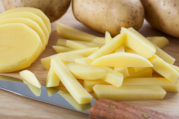 Cutting potatoes into chips stock photo