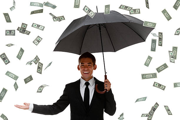istock Raining money on a businessman holding an umbrella 450806613
