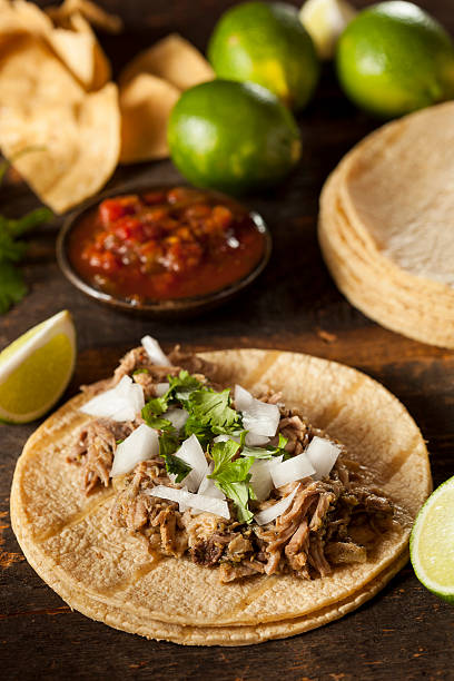 istock Table laid with pork tacos and chili sauce and lime 450810263