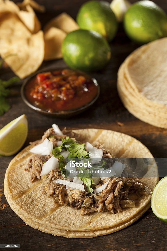 Table laid with pork tacos and chili sauce and lime Traditional Pork Tacos with Onion, Cilantro, and Lime Pork Stock Photo