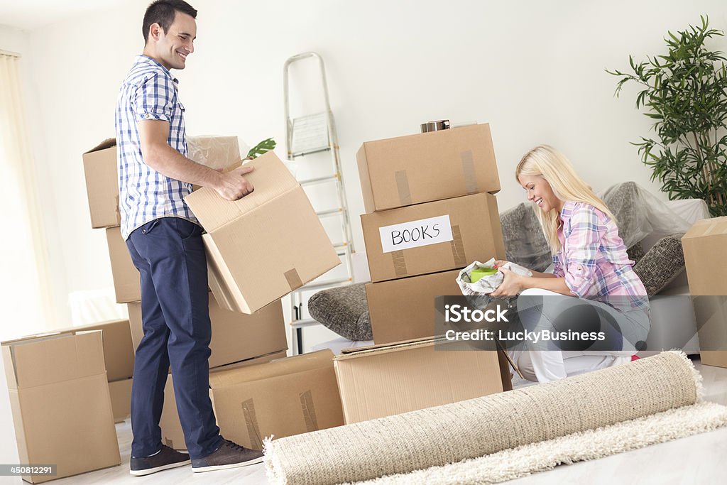 couple unpack moving boxes. A young couple unpack moving boxes. Adult Stock Photo