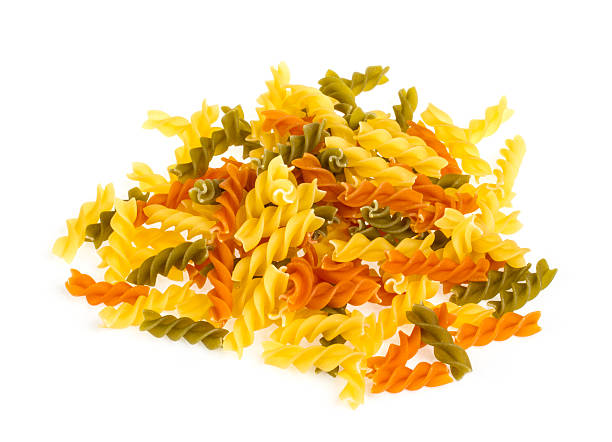istock Uncooked pasta fusilli in different colours, white background 450812869