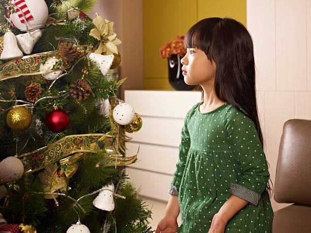 menina senta-se a árvore de natal - preschooler china solitude loneliness - fotografias e filmes do acervo