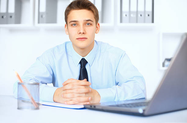 istock Young smiling businessman at his workplace in office 450824655