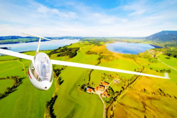young woman flying a glider plane over a beautiful landscape. 