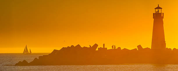 istock Light house with Sail boat at sunset 450835403