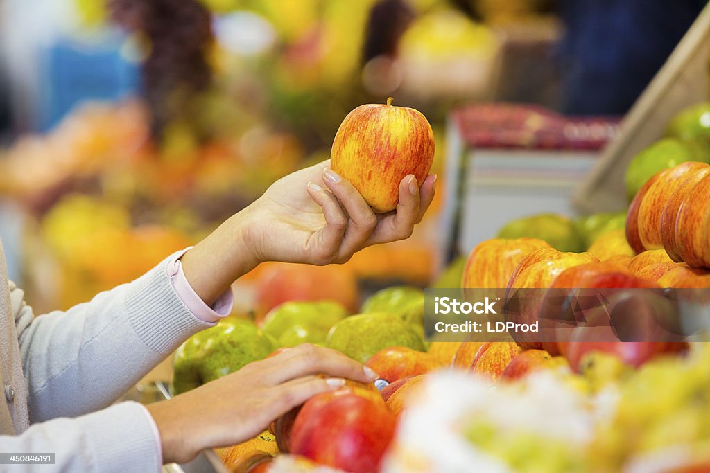 Woman buys fruits and vegetables at a market Female close-up hand store apple orange Basket Adult Stock Photo