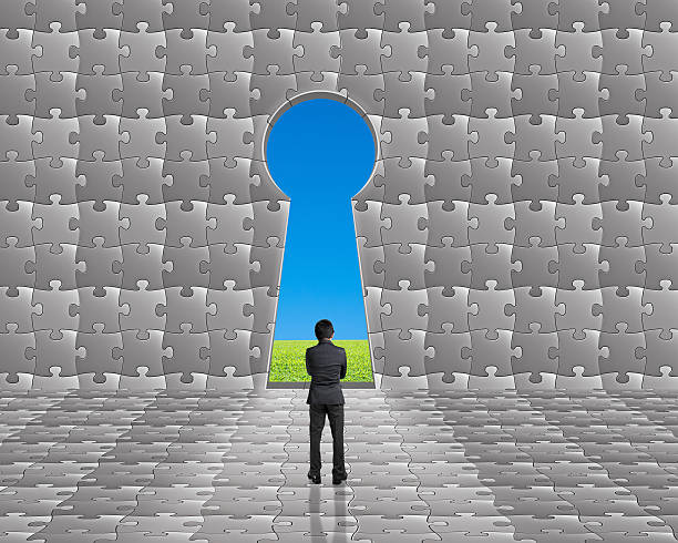 istock Businessman stand toward key hole shape door on puzzles wall 450866473