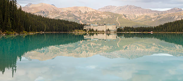 Chateau Lake Louise and the Lake Louise Ski runs reflected in the lake in Banff National Park, Alberta