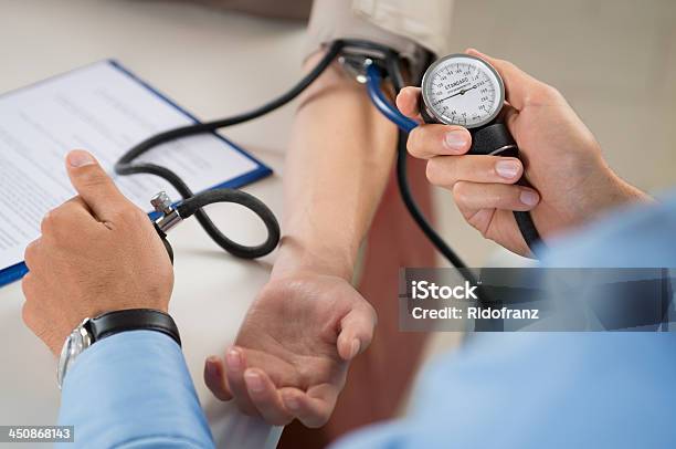 Doctor Measures Pressure In The Patient Stock Photo - Download Image Now - Blood Pressure Gauge, Checking - Sports, Healthcare And Medicine