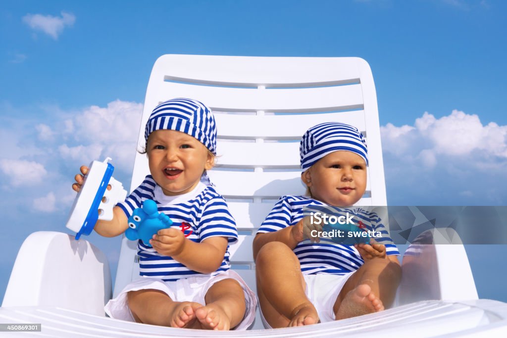 Crianças jogar em branco Espreguiçadeira contra o céu azul - Royalty-free Bebés Meninas Foto de stock