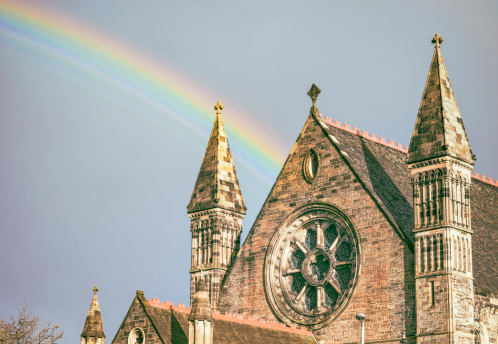 Following a rainstorm, the end of a rainbow behind a church in Edinburgh, Scotland.