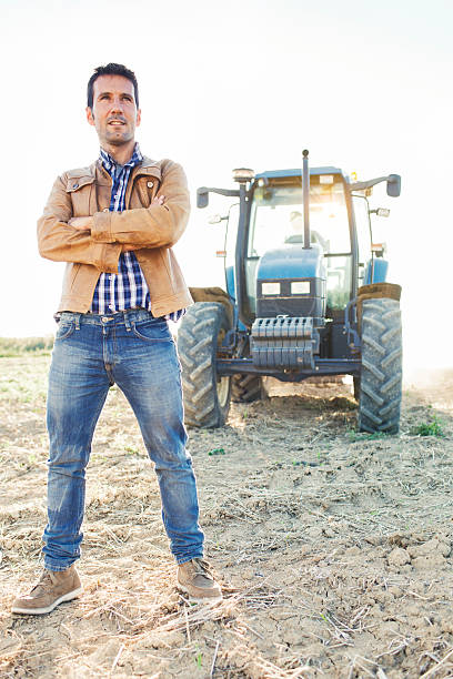 istock Tractor and farmer in a field. 450874081