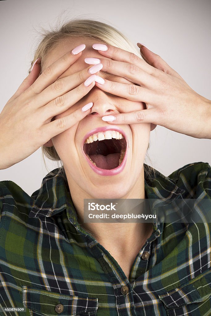 Can't see you, pretty blond woman hiding behind her hands Attractive young blond woman shouting ,isolated on white background Adult Stock Photo