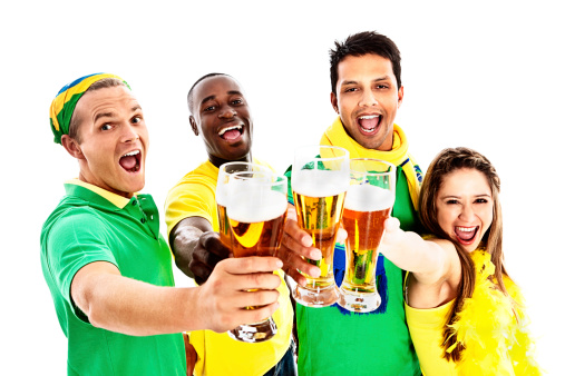 Four excited and enthusiastc soccer fans in Brazilian team colors cheer on their team They raise their beer glasses in a toast.