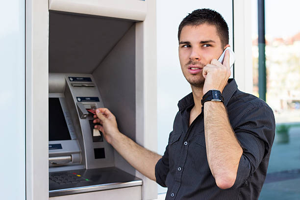 istock Handsome man on the phone at ATM 450908723
