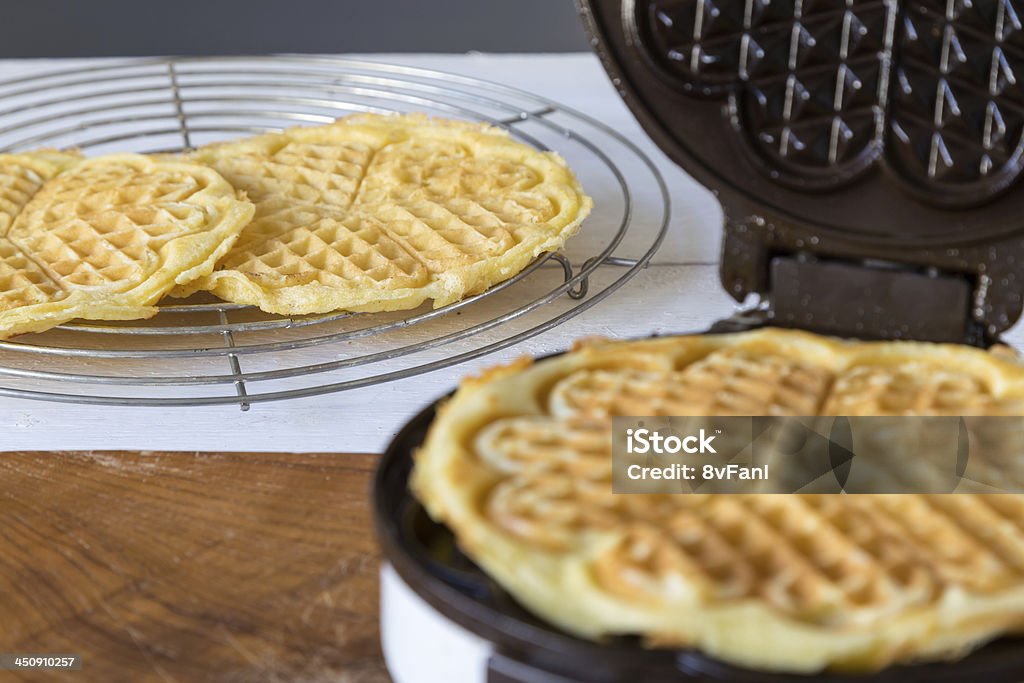 Waffle Makers in operation Homemade waffles are cooked in a waffle iron Baked Stock Photo