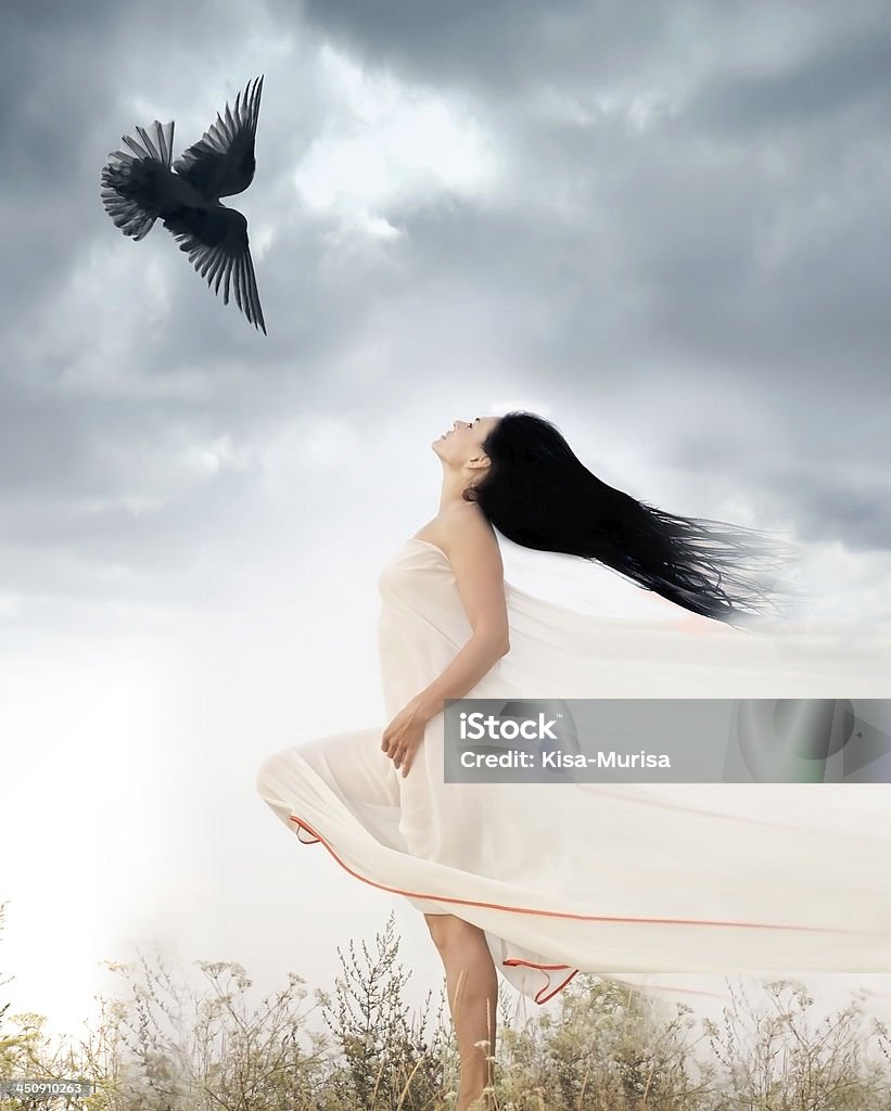 Beautiful young woman waving hair opposite to flying bird outdoors Beautiful young woman waving her hair opposite to flying bird. Freedom concept Angel Stock Photo