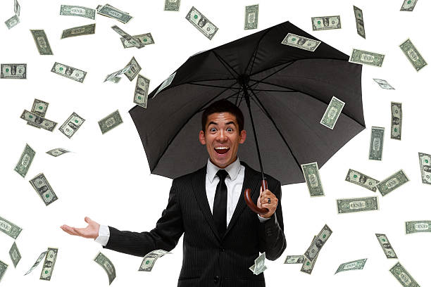 Excited businessman raining money Excited busienssman looking at camera in a money rain storm pennies from heaven stock pictures, royalty-free photos & images