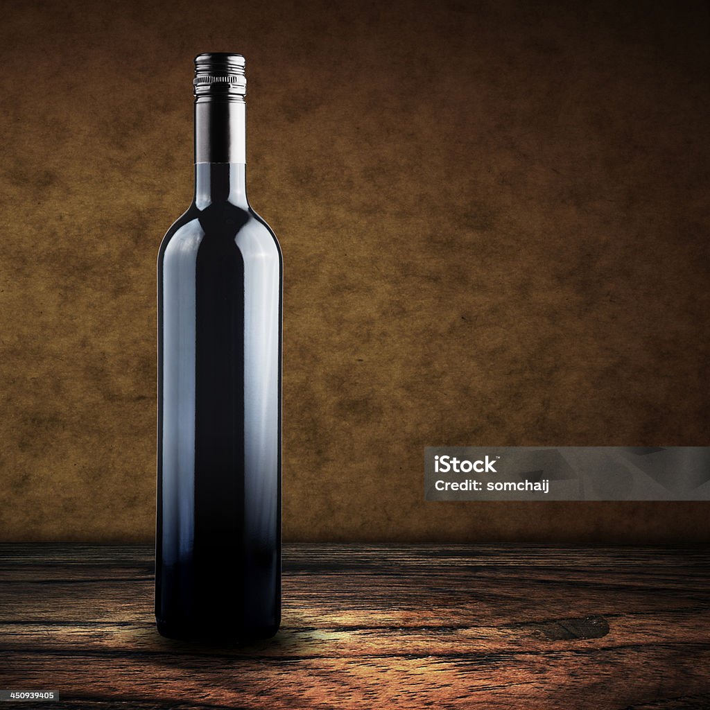 Butelka czerwonego wina na drewniany stół - Zbiór zdjęć royalty-free (Alkohol - napój)