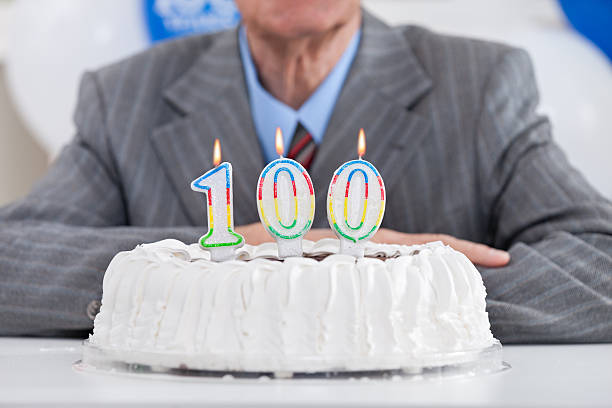 One hundred birthday birthday cake with lit candles for a century, one hundredth birthday number 100 stock pictures, royalty-free photos & images
