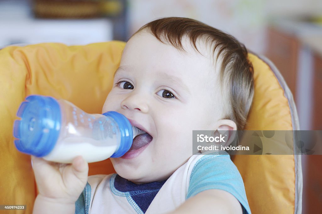Sorrindo bebê bebidas leite de uma garrafa pequena - Foto de stock de Bebê royalty-free