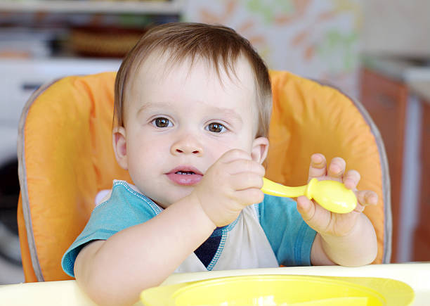 istock lovely baby with spoon 450974259