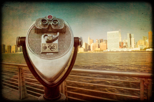 Retro style image of coin operated binoculars with view of New York City