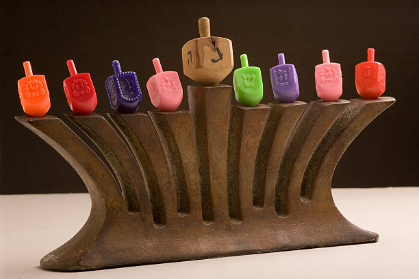 Menorah with dreidle flames on black stock photo