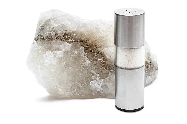 Rock salt with saltshaker isolated on white background