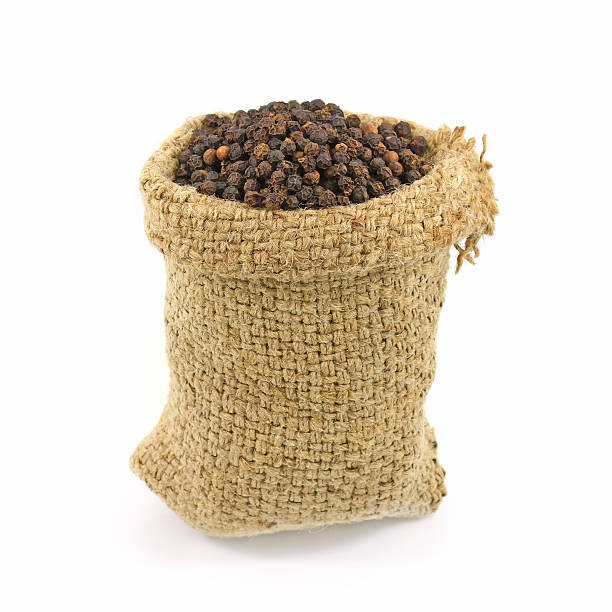 istock Black pepper packed in sacks hemp isolated white background. 451003469