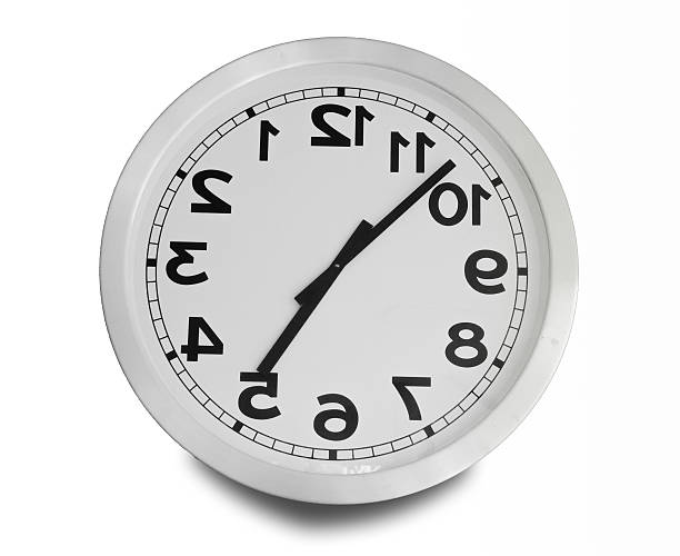 Clock turn upside down isolated on white background stock photo