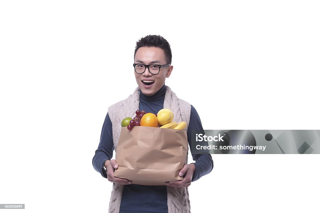 Asian men buy fruit Portrait of a cheerful young man carrying large bag of groceries. Isolated on white. Holding Stock Photo