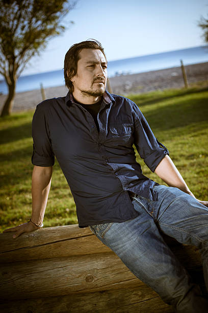 istock Young man sitting in nature 451013989