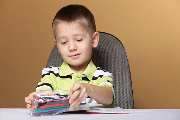 istock Young cute boy draws with color pencils 451017365