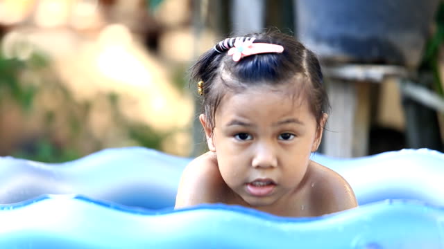 asia girl  playing in a paddling pool