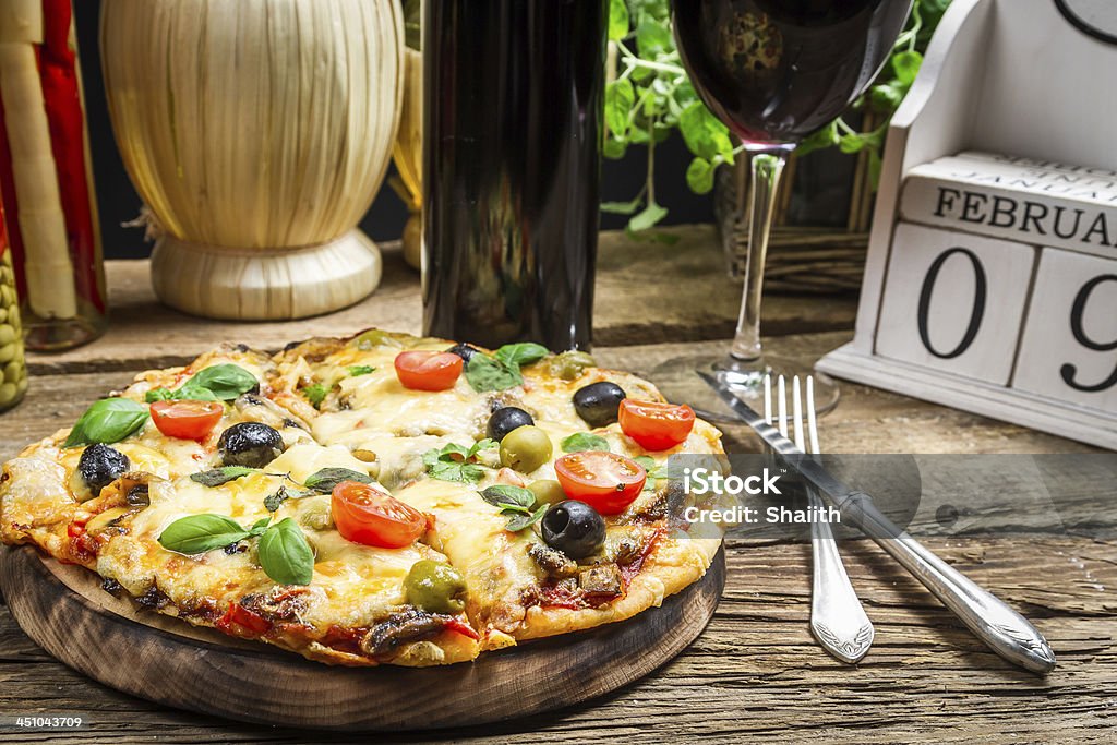 Freshly pizza served with red wine Basil Stock Photo