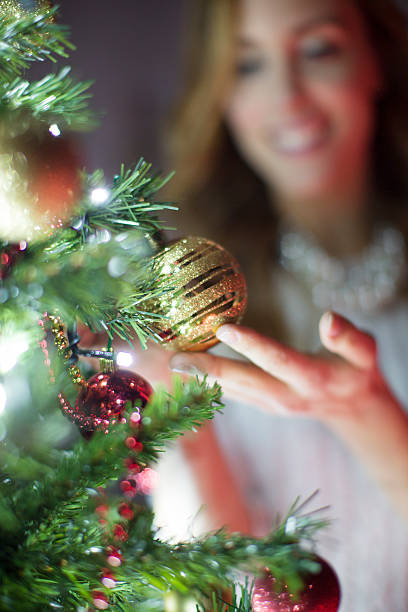istock Smiling Woman Decorating Christmas Tree. 451044751