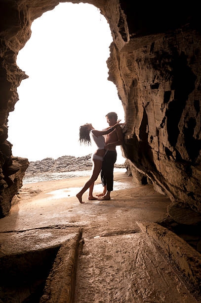 istock Young attractive couple leaning on rock archway 451059129