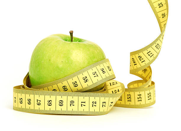 istock green apple with a heart symbol against white background 451064989