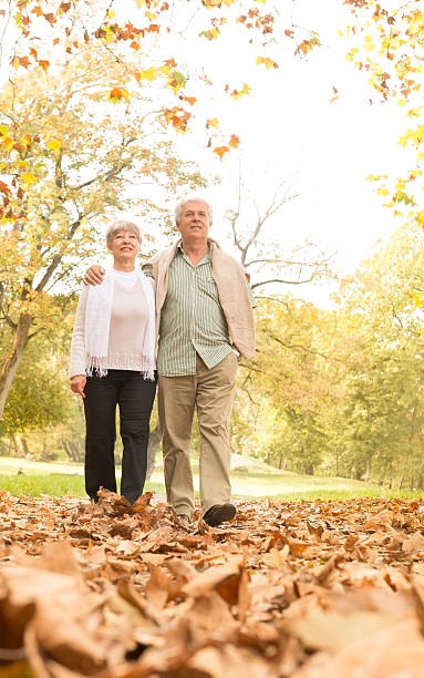 istock Senior Couple Walking In Park 451070747